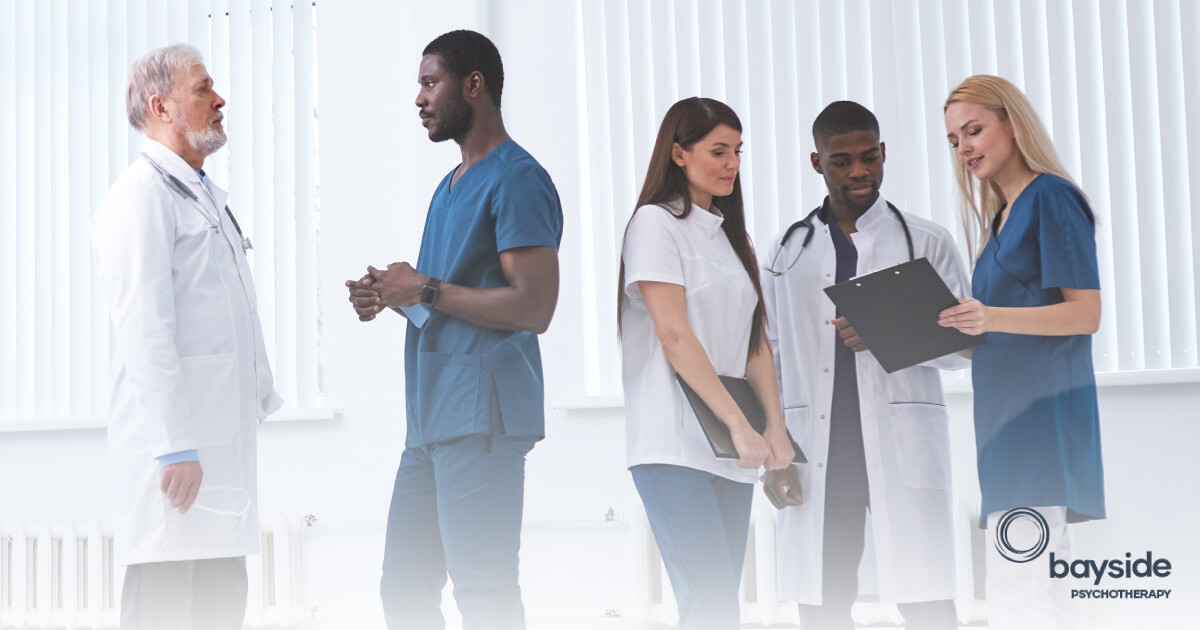 image with a group of medical workers in white and blue clothes and the Bayside Psychotherapy logo