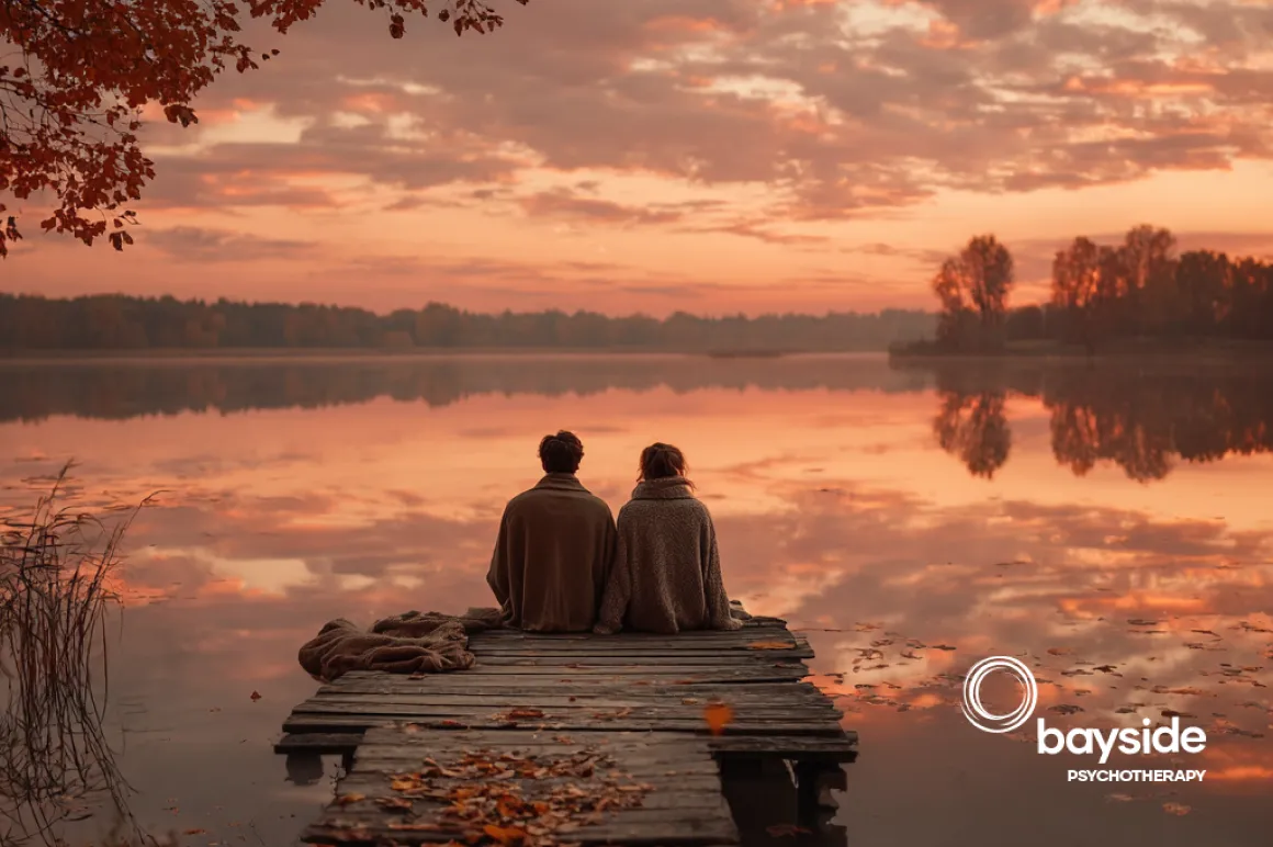 Couple sitting by serene lake